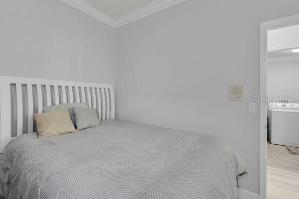 721 Hardwood Cir, Orlando, FL 32828 - bedroom with crown molding and wood finished floors