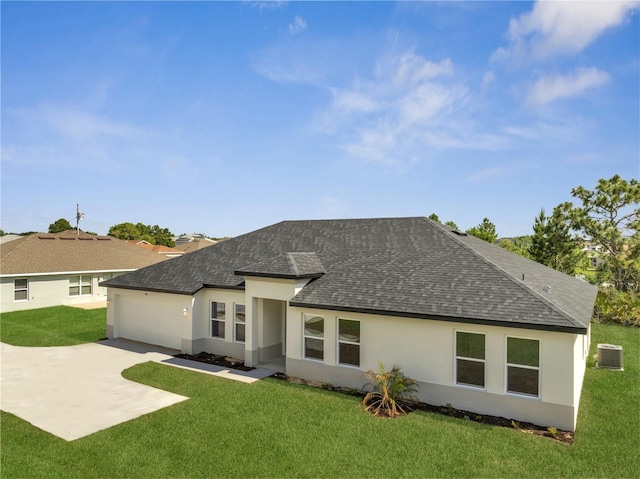 502 Viceroy Ct, Kissimmee, FL 34758 - back of property with a shingled roof, stucco siding, concrete driveway, central air condition unit, and a yard