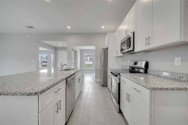 502 Viceroy Ct, Kissimmee, FL 34758 - kitchen with stainless steel appliances, a sink, white cabinets, a kitchen island with sink, and recessed lighting