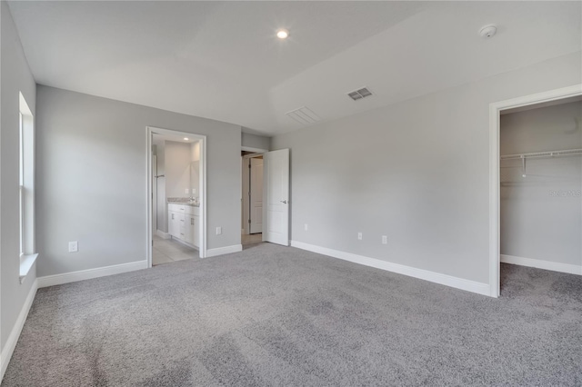 502 Viceroy Ct, Kissimmee, FL 34758 - unfurnished bedroom featuring light colored carpet, a spacious closet, baseboards, recessed lighting, and ensuite bathroom