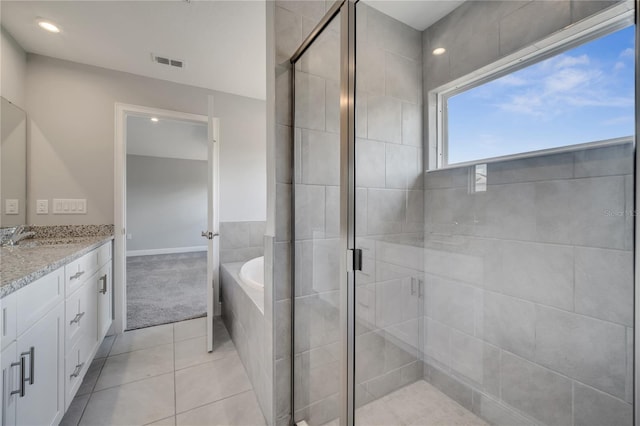502 Viceroy Ct, Kissimmee, FL 34758 - bathroom featuring a shower stall, tile patterned floors, a bath, and vanity