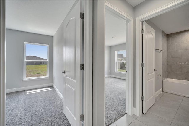 502 Viceroy Ct, Kissimmee, FL 34758 - corridor featuring light carpet, baseboards, and light tile patterned floors