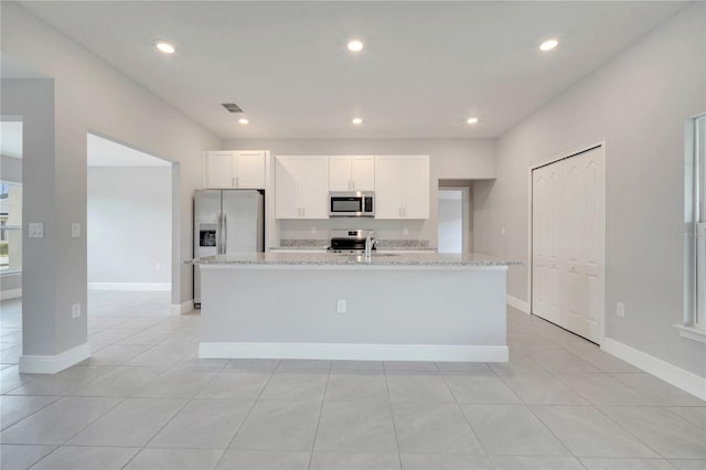 502 Viceroy Ct, Kissimmee, FL 34758 - kitchen with stainless steel appliances, an island with sink, white cabinetry, light stone countertops, and recessed lighting