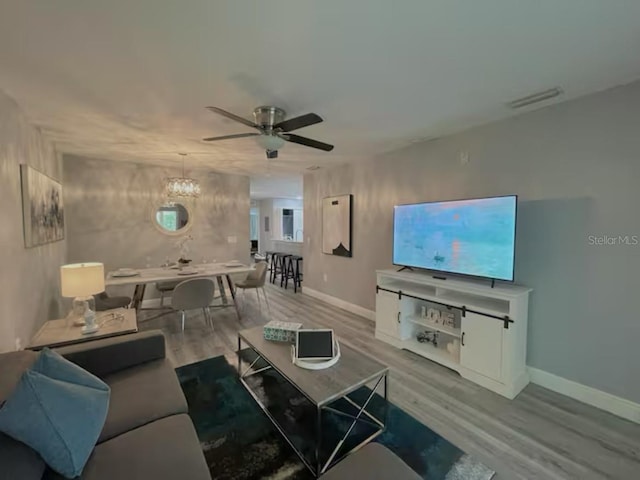2798 Club Cortile Cir Unit A, Kissimmee, FL 34746 - living room with wood finished floors, ceiling fan, baseboards, and a chandelier