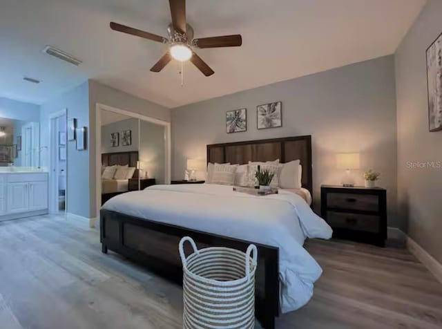 2798 Club Cortile Cir Unit A, Kissimmee, FL 34746 - bedroom with baseboards, wood finished floors, ensuite bathroom, and ceiling fan