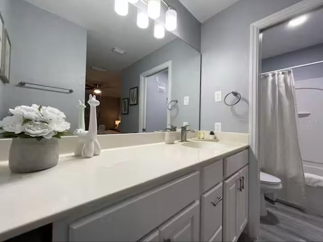 2798 Club Cortile Cir Unit A, Kissimmee, FL 34746 - full bath with toilet, vanity, ceiling fan, wood finished floors, and shower / tub combo with curtain