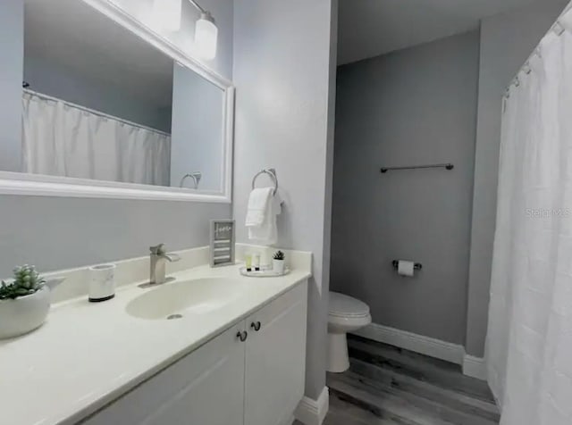 2798 Club Cortile Cir Unit A, Kissimmee, FL 34746 - full bath featuring toilet, wood finished floors, vanity, baseboards, and a shower with curtain