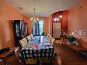 1107 Dartford Dr, Kissimmee, FL 34758 - dining space featuring a chandelier, wood finished floors, and arched walkways