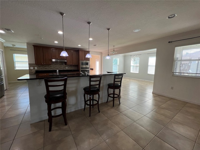 3003 Cobham Rd, Kissimmee, FL 34758 - kitchen featuring stainless steel appliances, a kitchen breakfast bar, healthy amount of natural light, recessed lighting, and backsplash