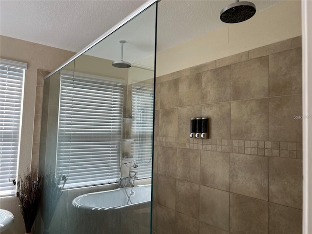 3003 Cobham Rd, Kissimmee, FL 34758 - bathroom featuring a tile shower and a textured ceiling