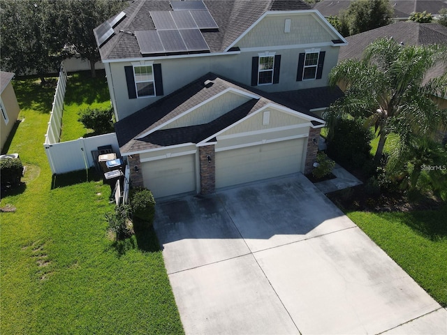 3003 Cobham Rd, Kissimmee, FL 34758 - view of front of home featuring stone siding, roof with shingles, concrete driveway, solar panels, and stucco siding