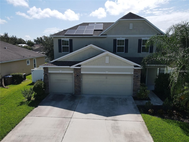 3003 Cobham Rd, Kissimmee, FL 34758 - view of front of home featuring stone siding, driveway, roof mounted solar panels, an attached garage, and a front lawn