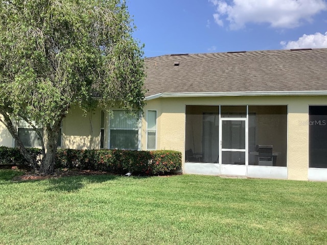 88 Club Villas Ln, Kissimmee, FL 34744 - rear view of house with a sunroom, a lawn, roof with shingles, and stucco siding