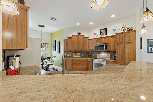 1258 Donalds Pl, The Villages, FL 32162 - kitchen with white electric range oven, stainless steel microwave, decorative backsplash, a chandelier, and hanging light fixtures
