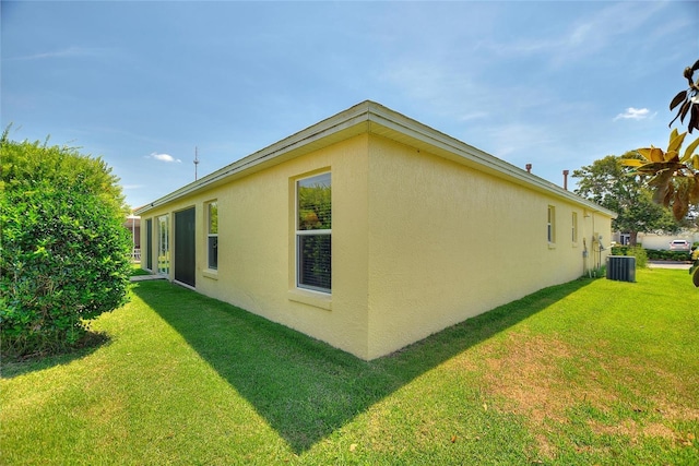1258 Donalds Pl, The Villages, FL 32162 - view of side of property featuring stucco siding, central AC unit, and a yard