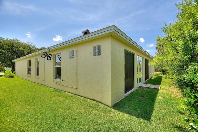 1258 Donalds Pl, The Villages, FL 32162 - back of house featuring stucco siding and a lawn
