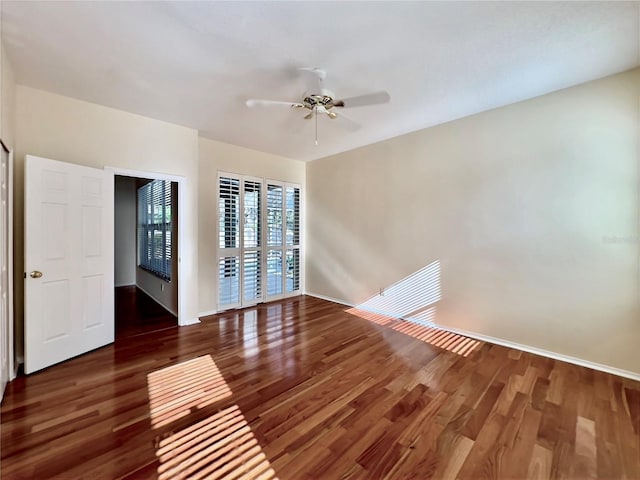 spare room featuring a ceiling fan, wood finished floors, and baseboards