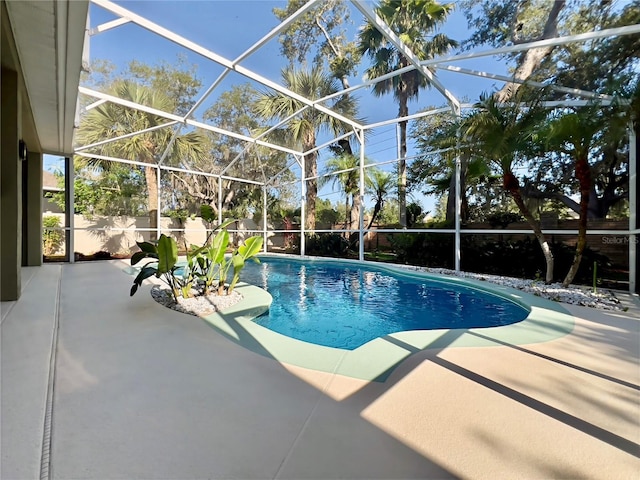 view of swimming pool with a patio and a lanai