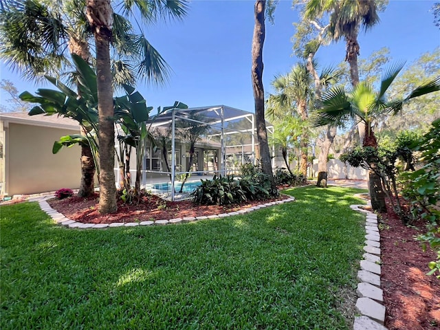 view of grassy yard featuring a lanai and an outdoor pool
