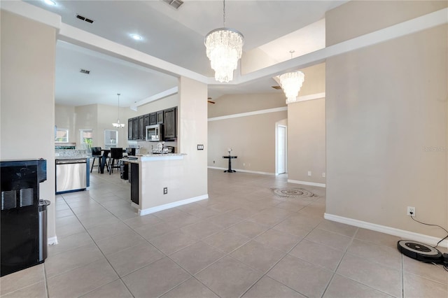 3211 Countryside View Dr, Saint Cloud, FL 34772 - kitchen featuring appliances with stainless steel finishes, a chandelier, light tile patterned flooring, light countertops, and lofted ceiling