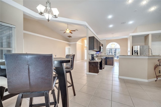 3211 Countryside View Dr, Saint Cloud, FL 34772 - dining area with vaulted ceiling, baseboards, ceiling fan, light tile patterned floors, and arched walkways