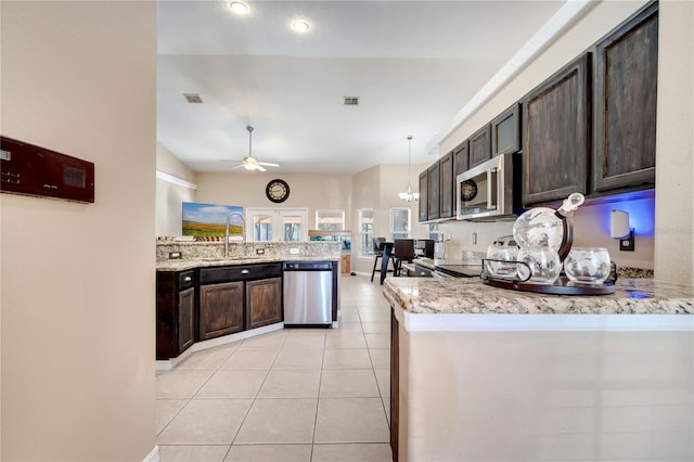 3211 Countryside View Dr, Saint Cloud, FL 34772 - kitchen featuring appliances with stainless steel finishes, a ceiling fan, dark brown cabinets, light tile patterned floors, and a peninsula