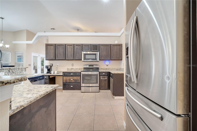 3211 Countryside View Dr, Saint Cloud, FL 34772 - kitchen with appliances with stainless steel finishes, dark brown cabinets, light tile patterned flooring, pendant lighting, and a chandelier