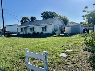 1309 N Thacker Ave, Kissimmee, FL 34741 - view of front of property with a front yard, a storage unit, and an outdoor structure