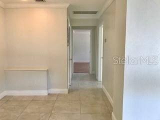 1309 N Thacker Ave, Kissimmee, FL 34741 - hallway with baseboards, light tile patterned floors, and crown molding