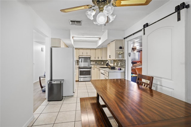 1408 Polk City Rd, Haines City, FL 33844 - dining area with a barn door, ceiling fan, light tile patterned flooring, and baseboards