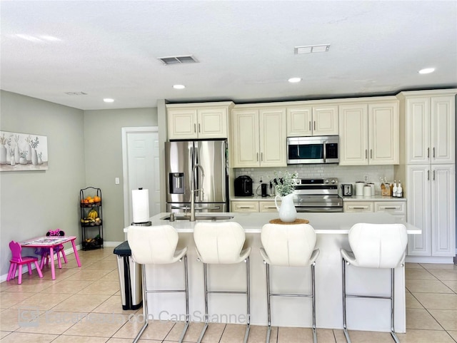 467 Martigues Dr, Kissimmee, FL 34759 - kitchen with stainless steel appliances, light tile patterned flooring, a kitchen bar, light countertops, and recessed lighting