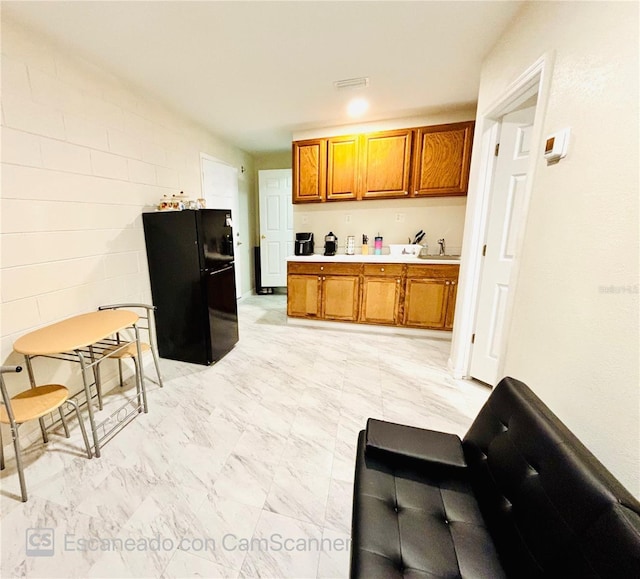467 Martigues Dr, Kissimmee, FL 34759 - kitchen featuring freestanding refrigerator, brown cabinets, light countertops, and a sink
