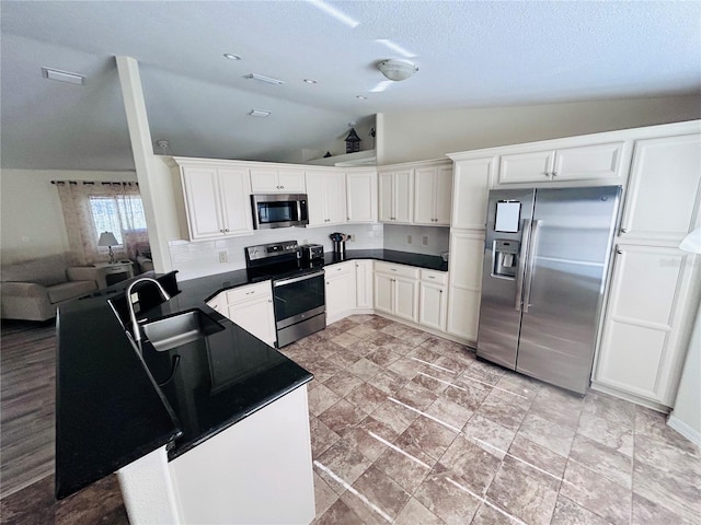 10237 SW 63rd Ave, Ocala, FL 34476 - kitchen featuring appliances with stainless steel finishes, vaulted ceiling, dark countertops, white cabinetry, and a textured ceiling