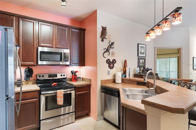 7521 Pellham Way, Kissimmee, FL 34747 - kitchen featuring stainless steel appliances, a sink, a peninsula, a breakfast bar, and light tile patterned floors