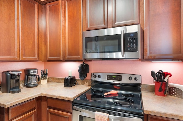 7521 Pellham Way, Kissimmee, FL 34747 - kitchen with appliances with stainless steel finishes, light countertops, and brown cabinets