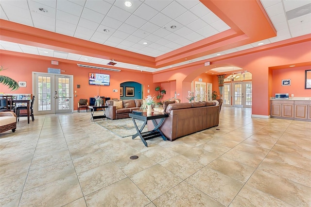 7521 Pellham Way, Kissimmee, FL 34747 - living area with french doors, a tray ceiling, arched walkways, plenty of natural light, and recessed lighting