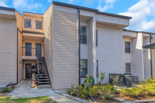 5151 Puritan Cir Unit 1022, Tampa, FL 33617 - view of building exterior featuring stairway and cooling unit