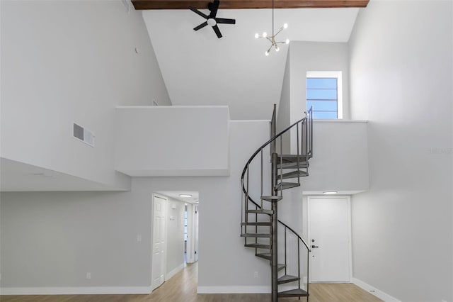 5151 Puritan Cir Unit 1022, Tampa, FL 33617 - stairway with high vaulted ceiling, wood finished floors, baseboards, a ceiling fan, and a chandelier