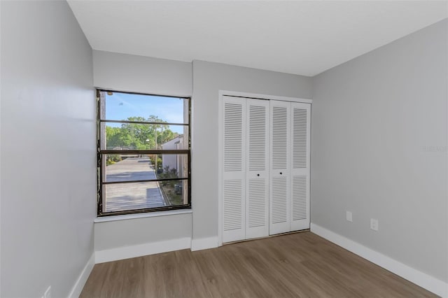 5151 Puritan Cir Unit 1022, Tampa, FL 33617 - unfurnished bedroom with wood finished floors, baseboards, and a closet