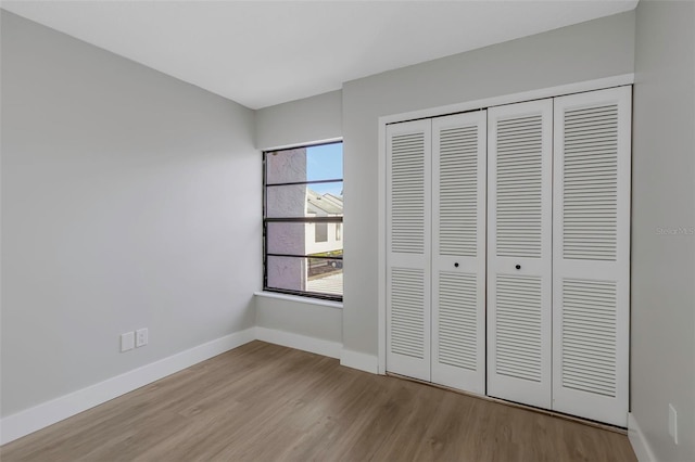 5151 Puritan Cir Unit 1022, Tampa, FL 33617 - unfurnished bedroom featuring wood finished floors, a closet, and baseboards