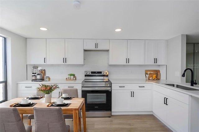 5151 Puritan Cir Unit 1022, Tampa, FL 33617 - kitchen with stainless steel electric range, a sink, light countertops, plenty of natural light, and recessed lighting