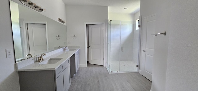 full bathroom with vanity, wood finished floors, and a stall shower