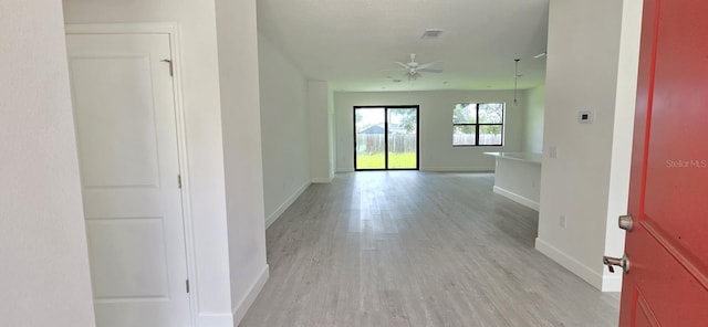 corridor featuring light wood-style floors and baseboards