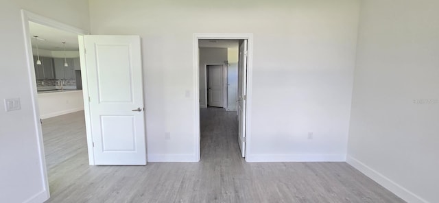 unfurnished bedroom featuring wood finished floors and baseboards