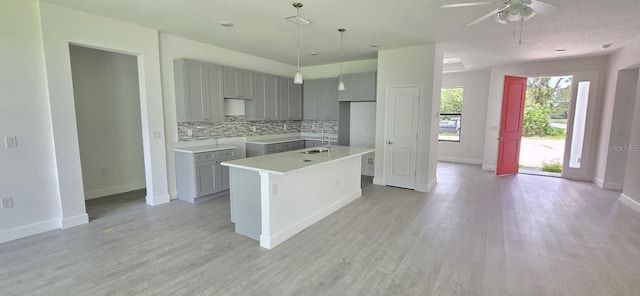 kitchen featuring gray cabinets, decorative backsplash, and baseboards