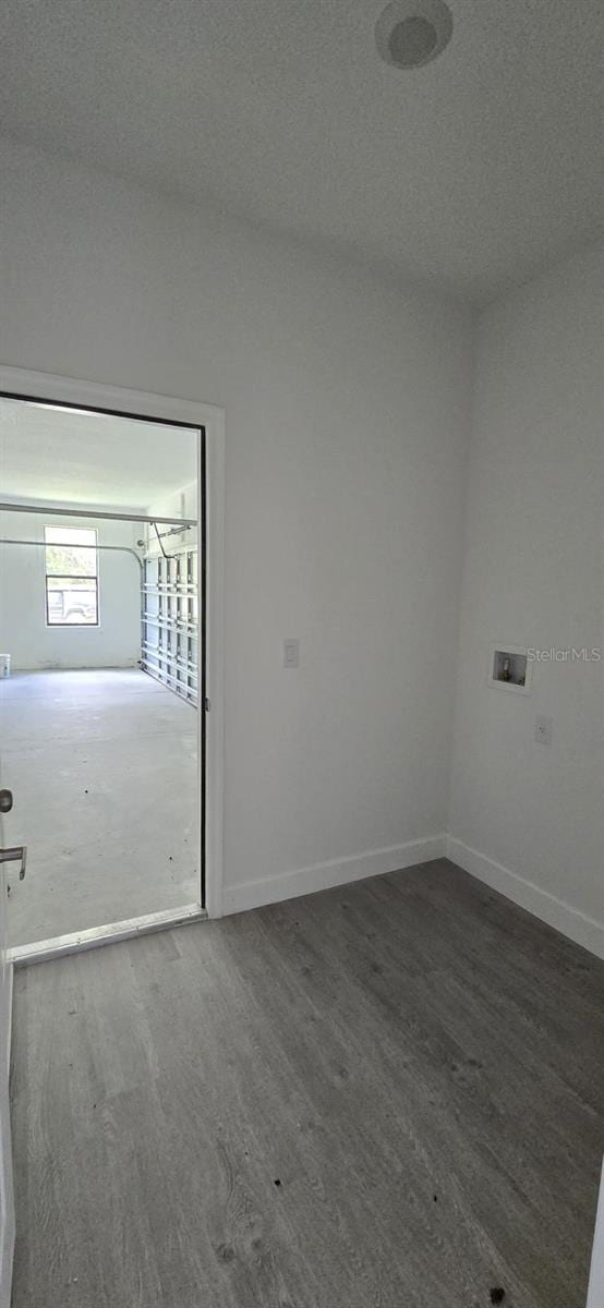 empty room with baseboards and wood finished floors