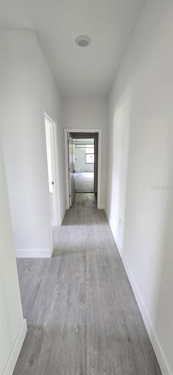 hall with wood finished floors and baseboards
