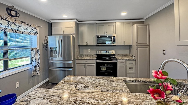 4218 Drexel Ave, Orlando, FL 32808 - kitchen with stainless steel appliances, wood finished floors, ornamental molding, light stone counters, and gray cabinets