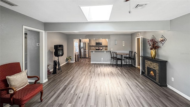 4218 Drexel Ave, Orlando, FL 32808 - living room with wood finished floors, a skylight, and a fireplace