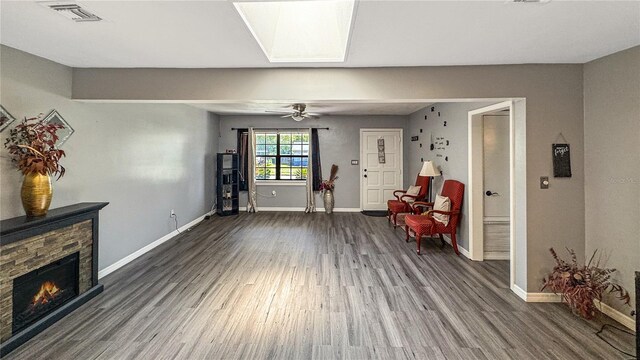 4218 Drexel Ave, Orlando, FL 32808 - sitting room with wood finished floors, a stone fireplace, and a ceiling fan